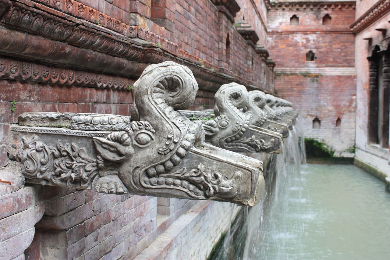 Ancient stone water tap (dhunge dhara) in Kathmandu Valley, showcasing traditional Newari architecture and cultural heritage.