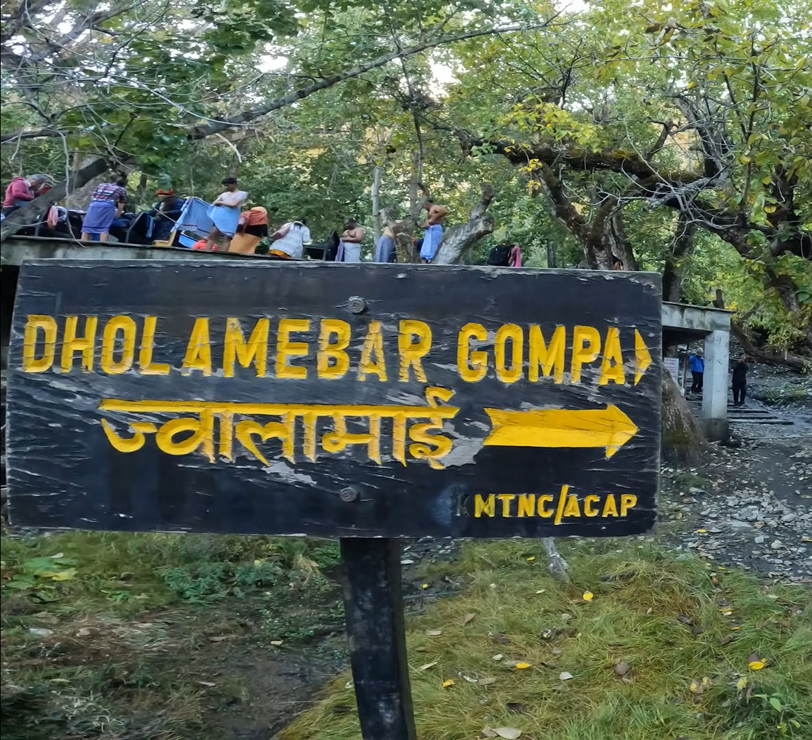 Direction boards at Muktinath Temple guiding pilgrims to key sites like the main shrine, 108 taps, and nearby trekking routes.