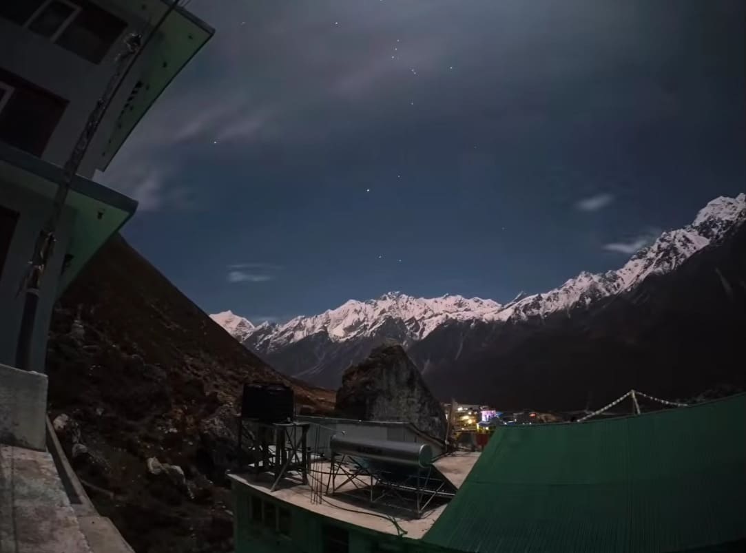 Stunning night view of the Langtang mountains, with starry sky illuminating the peaks and valley below.