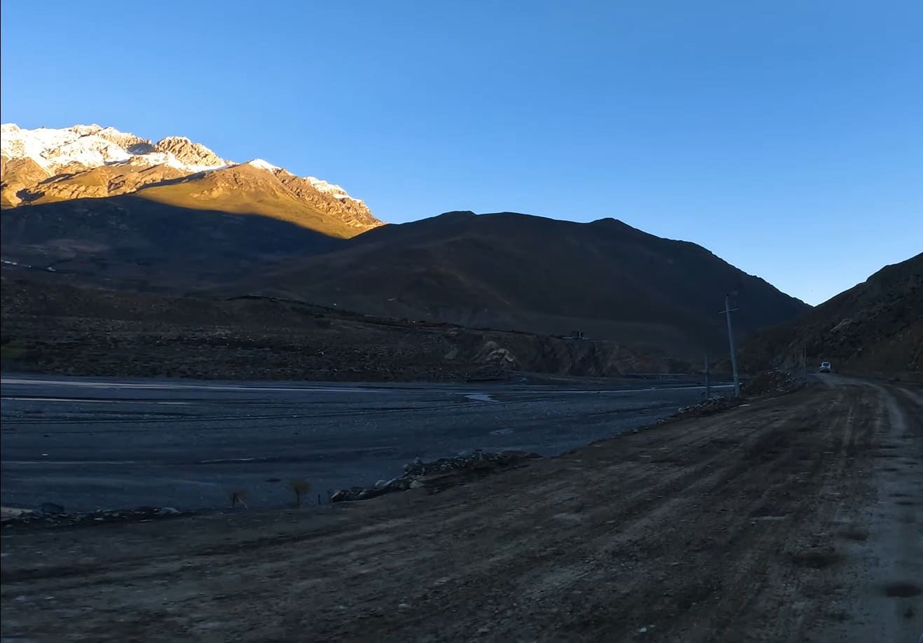 Stunning panoramic views of the Himalayan landscape surrounding Muktinath Temple, featuring rugged mountains, green valleys, and clear skies.