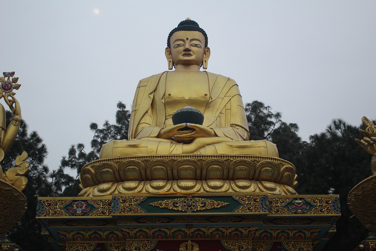 Swayambhunath Buddha statue with golden face, peaceful expression, and colorful prayer flags around the ancient hilltop stupa in Kathmandu.